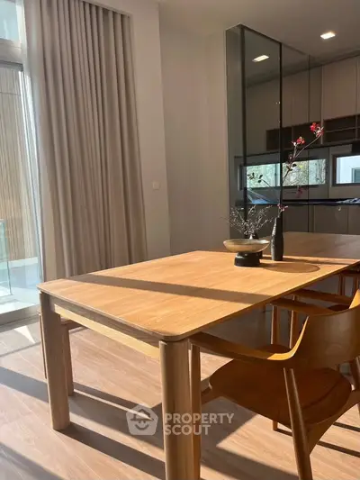 Modern dining area with natural light and sleek wooden furniture