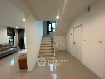 Spacious modern living area with staircase and sleek furniture