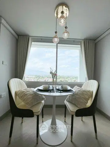 Chic dining nook with stunning view, elegant chairs, and modern lighting in a stylish apartment.