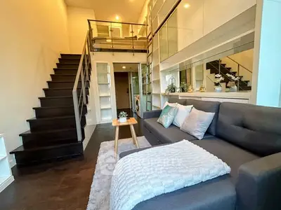 Modern duplex living room with stylish staircase and cozy seating area