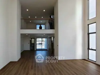 Spacious modern living room with high ceilings and large windows in a contemporary home.