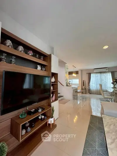 Spacious modern living room with stylish decor and large TV unit, perfect for family gatherings.