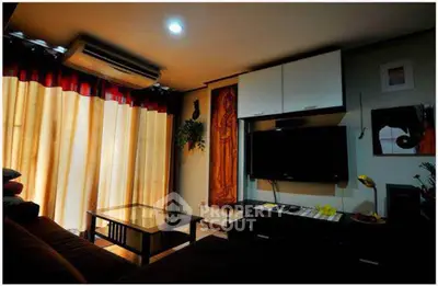 Cozy living room with modern decor, featuring a wall-mounted TV and elegant lighting.