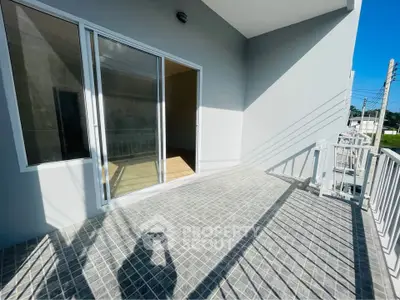 Spacious balcony with sliding glass doors and modern tile flooring, perfect for outdoor relaxation.