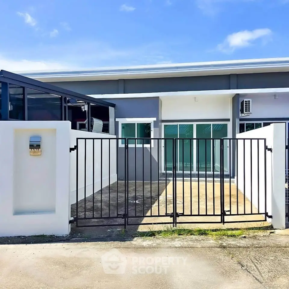 Modern single-story home with gated entrance and sleek exterior design.