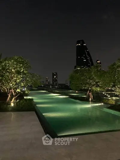 Luxurious rooftop pool with stunning city skyline view at night, perfect for relaxation and leisure.