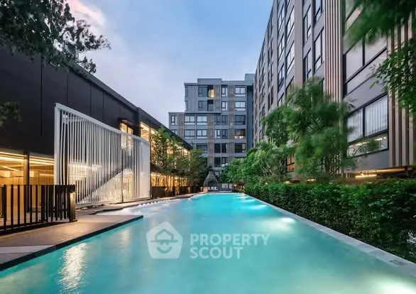 Luxurious modern apartment complex with a stunning outdoor pool and lush greenery.