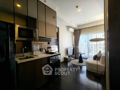 Modern open-plan living room with sleek kitchen and cozy seating area.