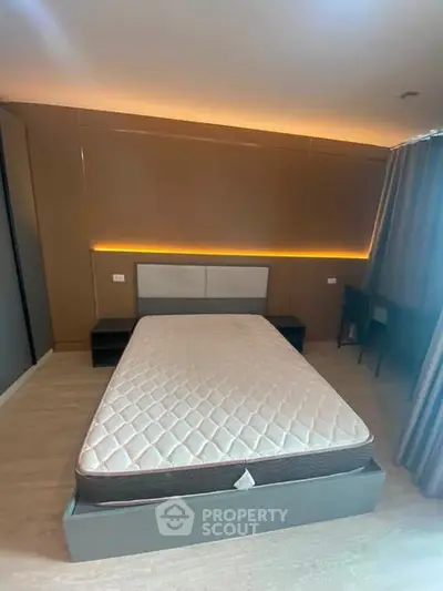 Modern bedroom with stylish lighting and minimalist design, featuring a comfortable bed and sleek furnishings.