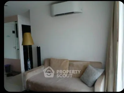 Cozy living room with beige sofa and modern air conditioning unit, perfect for relaxation.