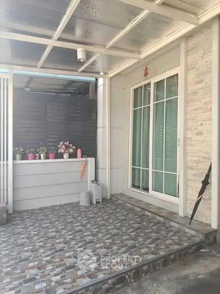 Charming exterior patio with tiled flooring and sliding glass doors, perfect for relaxation and outdoor decor.