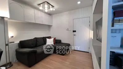 Modern living room with sleek design, featuring a cozy sofa and stylish lighting, perfect for relaxation.
