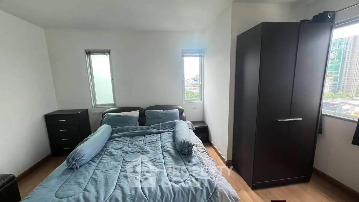 Cozy bedroom with modern furniture and city view, perfect for urban living.