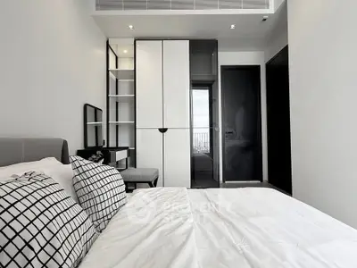 Modern bedroom with sleek design, featuring a stylish wardrobe and cozy bed setup.