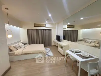 Modern studio apartment with cozy bedroom and dining area, featuring elegant decor and ample natural light.