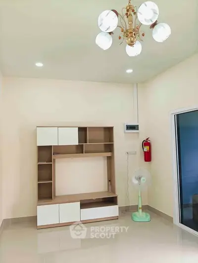 Modern living room with stylish shelving unit and elegant chandelier
