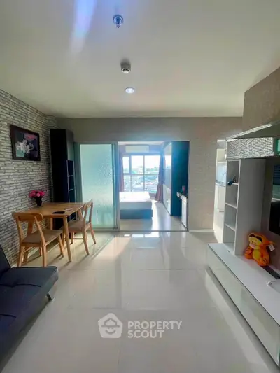 Bright modern living room with open layout and stylish decor, featuring a view into the bedroom.