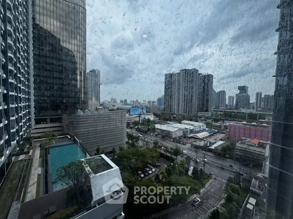 Stunning cityscape view from high-rise building with pool and urban skyline.