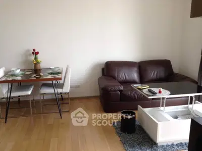 Cozy living room with leather sofa and dining area, perfect for relaxation.