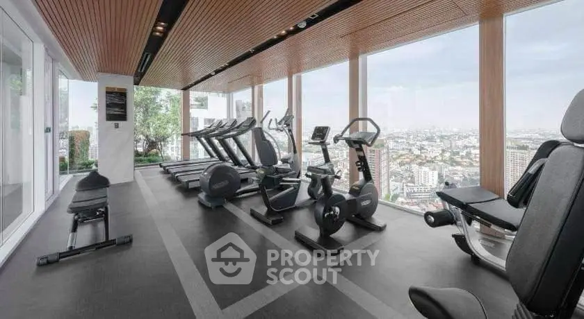 Luxury gym with panoramic city views and modern fitness equipment.