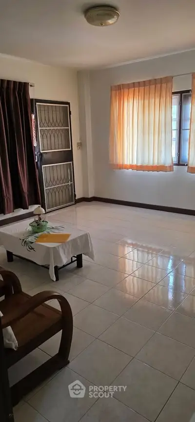 Spacious living room with natural light and elegant curtains in a cozy apartment.