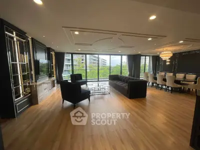 Luxurious modern living room with elegant decor and spacious dining area, featuring large windows and stylish furnishings.