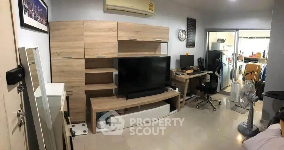 Modern living room with sleek wooden furniture and home office setup