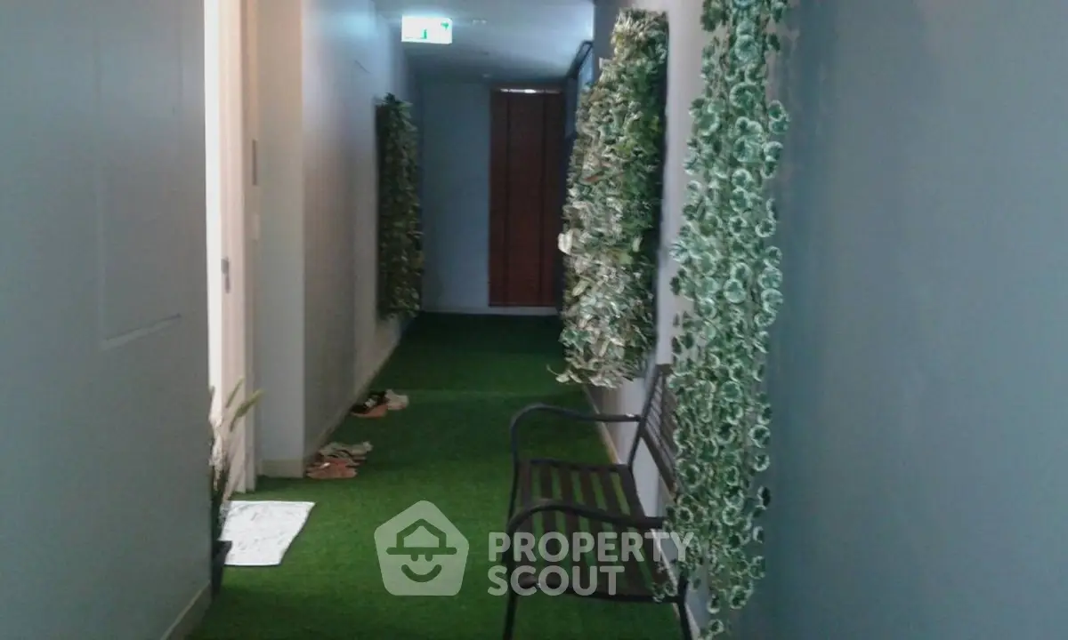 Modern corridor with green artificial grass flooring and decorative wall plants.