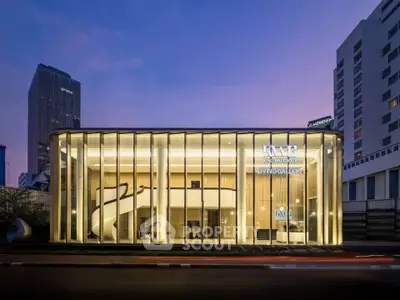 Stunning modern architectural building with glass facade at dusk, showcasing elegant design and urban sophistication.
