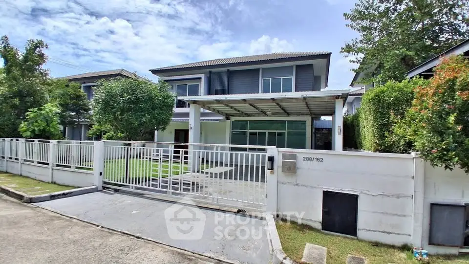 Modern two-story house with spacious front yard and gated entrance in a serene neighborhood.