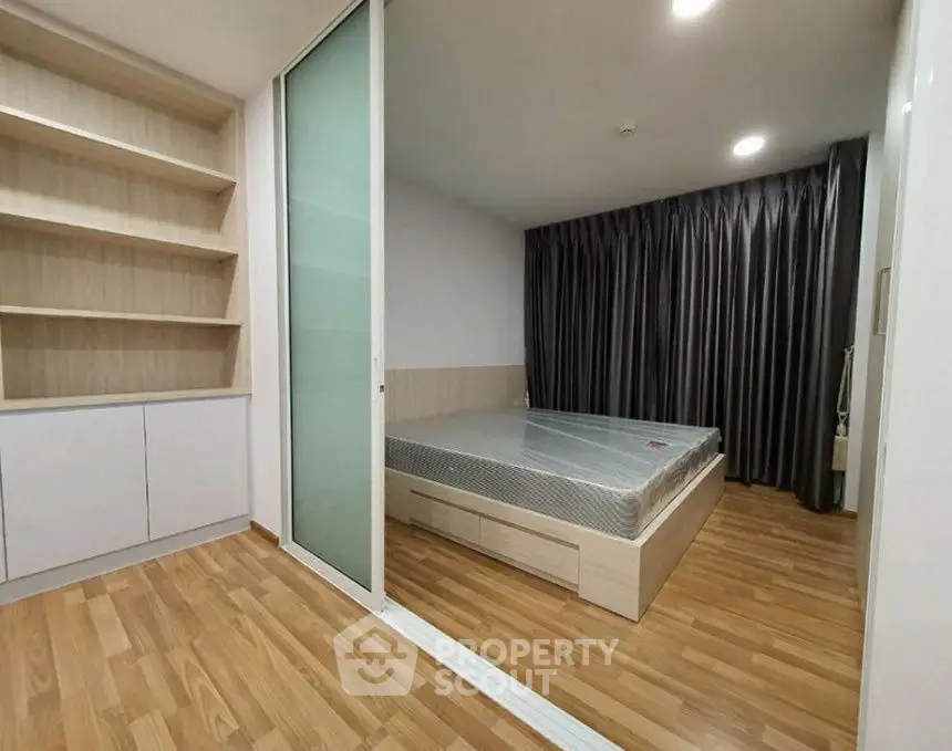 Modern bedroom with wooden flooring and built-in shelving
