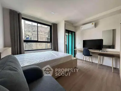 Modern bedroom with large window, air conditioning, and stylish furniture in urban apartment.