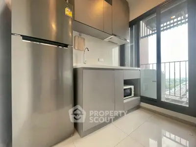 Modern kitchen with sleek appliances and balcony view in a stylish apartment.