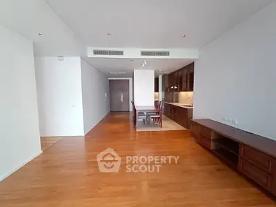 Spacious open-plan living and dining area with modern kitchen in luxury apartment.