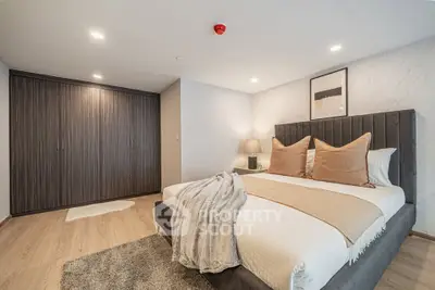 Luxurious bedroom with modern decor and spacious wardrobe in elegant apartment.