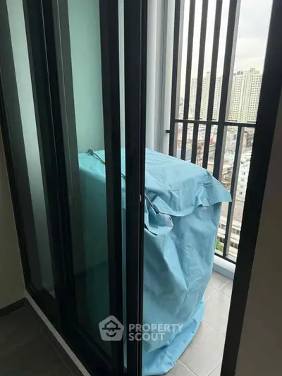 Modern apartment balcony with city view and covered appliance