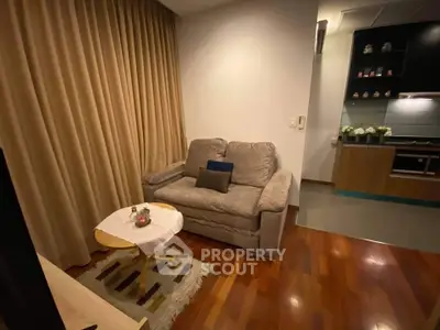 Cozy living room with plush sofa and modern kitchen in open layout apartment.
