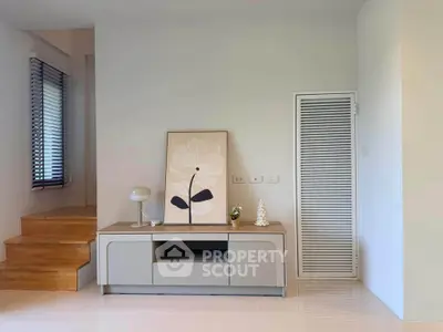 Modern living room with stylish decor and wooden staircase