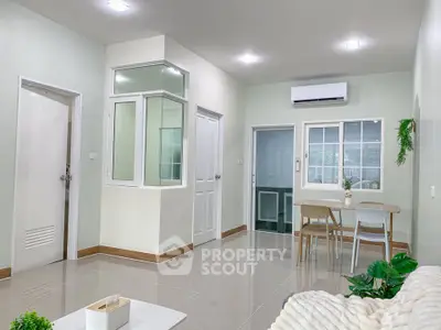 Modern living room with dining area and air conditioning, featuring sleek design and natural light.