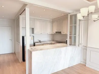 Elegant kitchen with marble countertop and classic cabinetry in bright apartment