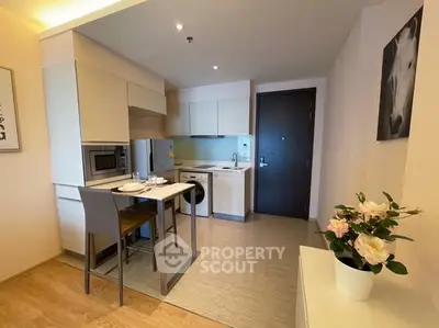 Modern compact kitchen with dining area and washing machine in cozy apartment.