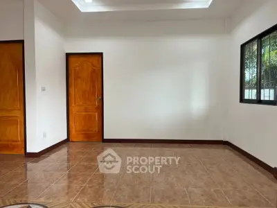 Spacious empty room with tiled floor and wooden doors, ready for customization.
