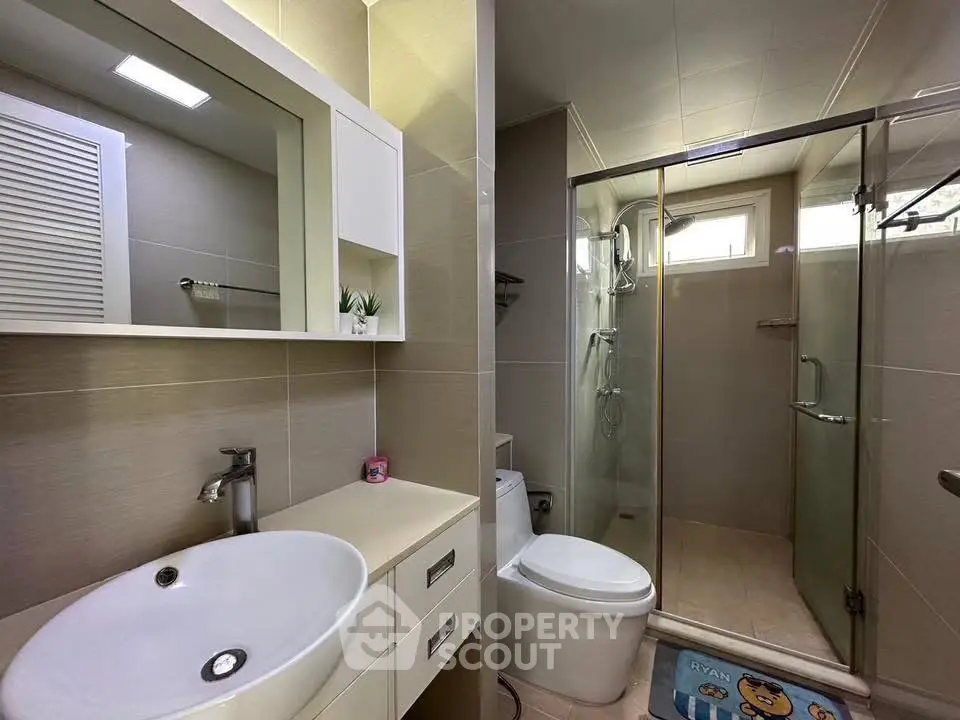 Modern bathroom with sleek fixtures and glass shower enclosure