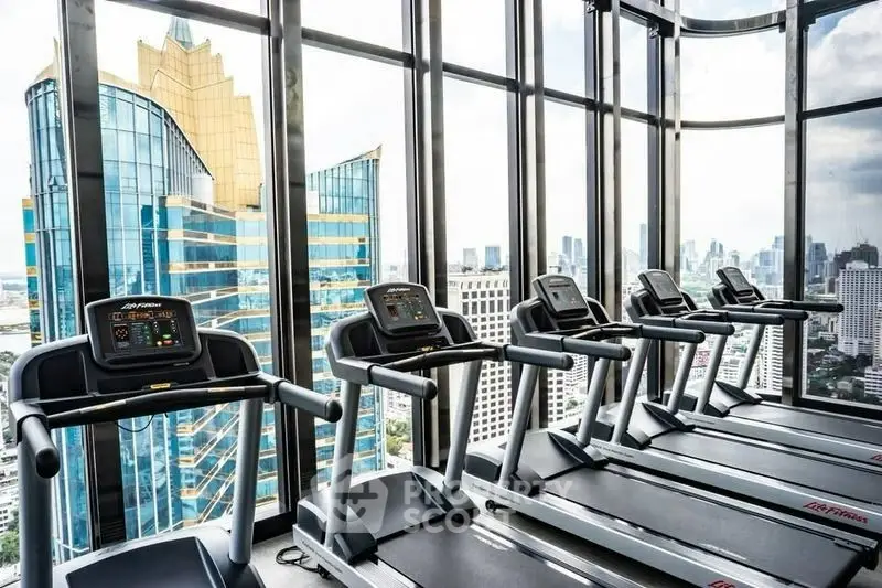 Luxurious high-rise gym with panoramic city views and modern treadmills.