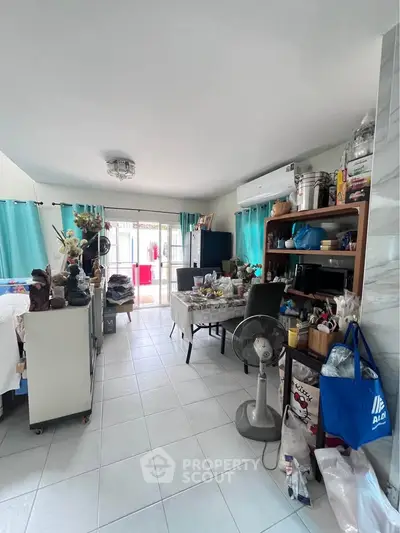 Spacious living room with modern decor and natural light, featuring a fan and air conditioning.