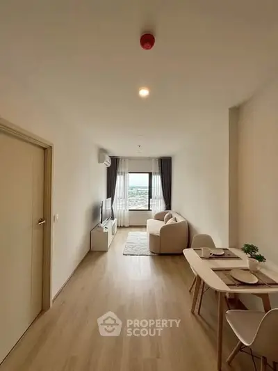 Modern living room with cozy sofa and dining area, featuring a large window with city view.