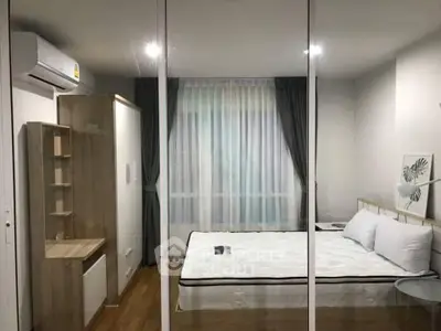 Modern bedroom with glass partition, wooden flooring, and stylish decor in a contemporary apartment.