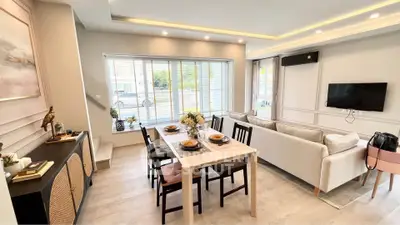 Modern living room with dining area, stylish decor, and large windows for natural light.