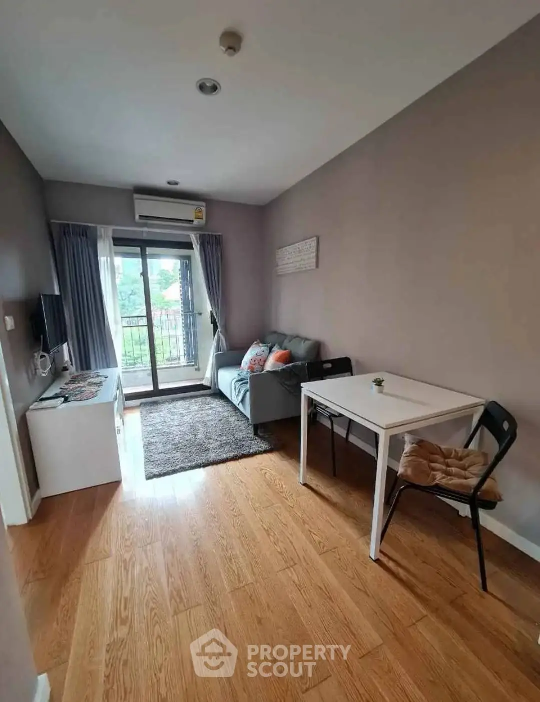 Cozy living room with balcony access, featuring modern decor and ample natural light.