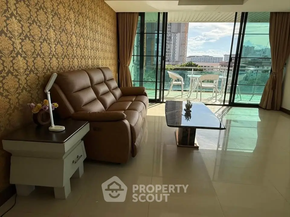 Spacious living room with elegant decor and large balcony offering stunning city views.